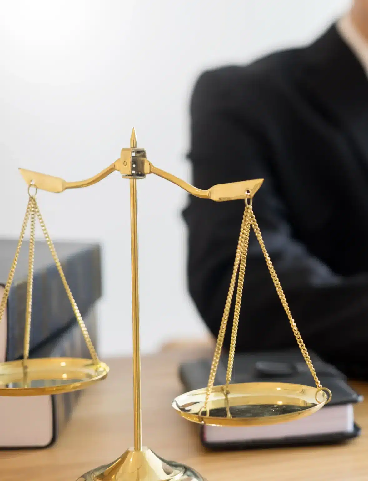 محامٍ يجلس على المكتب مع ميزان العدالة في مكتب محاماة