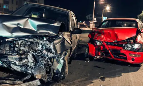 تصادم بين سيارتين في شارع داخل المدينة ليلًا