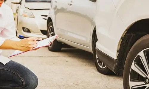 محامي تأمين سيارات يفحص أضرار مركبة عميل للتحقق من تقييم شركة التأمين