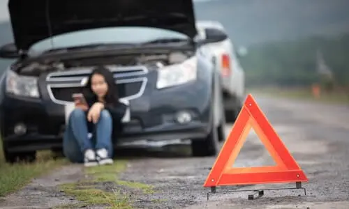 جهاز تحذير مبكر وسيارة غير واضحة في الخلفية وامرأة تطلب المساعدة بعد حادث