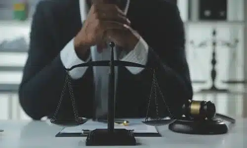 محامي حادث انعطاف يسار يجلس خلف مكتبه ويداه متشابكتان بانتظار عميل