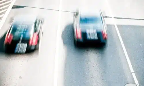 سيارتان تتسابقان بسرعة عالية في شارع داخل المدينة