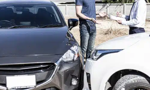 سائقان يتحدثان ويفحصان الأضرار بعد حادث، مناسب لقضايا سائق غير مؤمّن أو ناقص التأمين في سافانا.