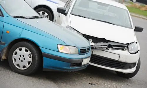 سيارتان زرقاء وبيضاء متوقفتان بعد حادث تصادم.