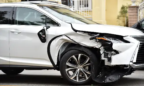 صورة لسيارة دفع رباعي متضررة من جهة الراكب بعد حادث على الطريق.