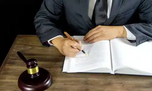 محامي تعويضات العمال في غينزفيل يدوّن ملاحظات على مكتب خشبي داخل مكتبه.
