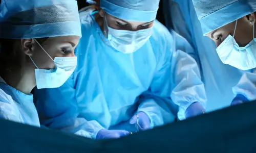 فريق طبي متجمع حول مريض داخل غرفة العمليات أثناء إجراء الجراحة.