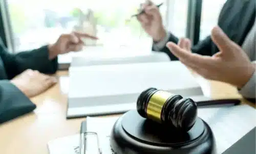 محامٍ يناقش تفاصيل قضية إصابات شخصية مع عميل أثناء التحضير لتقديم مطالبة.