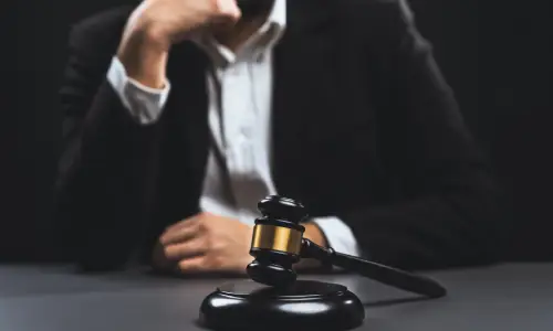 محامي قضايا المنتجات المعيبة يستمع باهتمام واضعًا ذقنه على قبضته المغلقة.