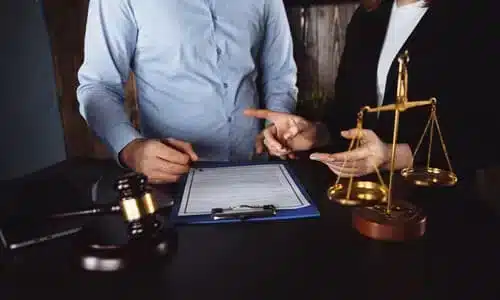 محامية تشرح لعميلها تفاصيل وثيقة التأمين الخاصة به داخل مكتب.