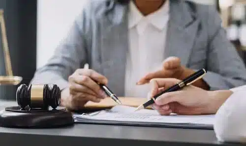 محامٍ لقضية سائق غير كافي التأمين يناقش مطالبة إصابة شخصية مع عميل على مكتب.