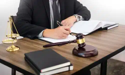 محامي قضايا الانزلاق والسقوط يعمل على ملف مفتوح فوق المكتب لقضية أحد العملاء