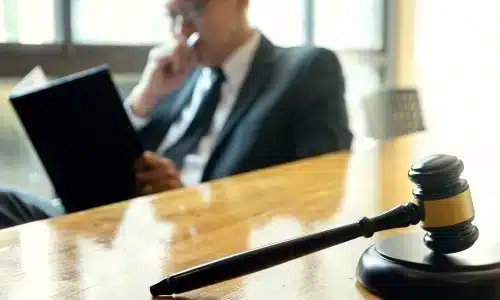 محامي حوادث دراجات يجلس في مكتب محاماة بأريزونا، يقرأ ملف قضية ويده تغطي فمه.