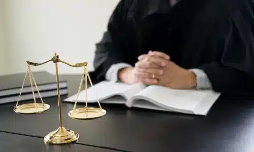 محامي حوادث قوارب يجلس إلى طاولة داخل مكتب محاماة بأريزونا ويداه متشابكتان.