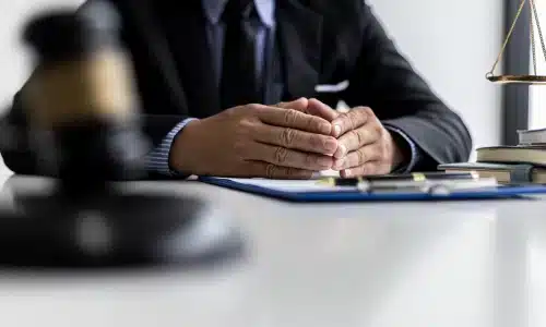 محامي حوادث شاحنات تجارية يجلس في مكتبه بأريزونا ويداه فوق الطاولة أمامه.