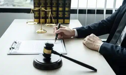 محامي منتجات معيبة في أريزونا يجلس داخل مكتب ويُوثّق مستندات على المكتب.