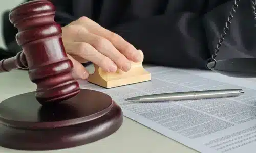 محامي حوادث هروب بعد التصادم في أريزونا يضع يدًا على كتاب مفتوح وهو جالس داخل المكتب.