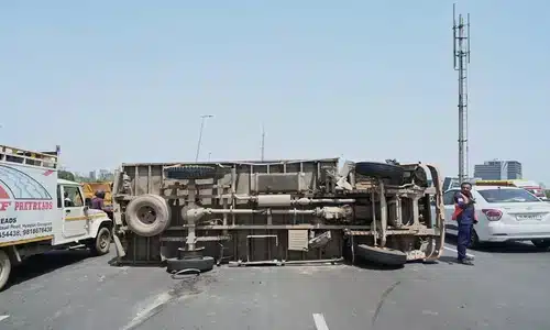 شاحنة منقلِبة على الطريق بعد انفجار إطار خلفي، ما تسبب بازدحام مروري.