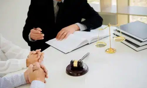 محامي حوادث الشاحنات التجارية يناقش قضية مع عملائه داخل مكتب محاماة في هيوستن.