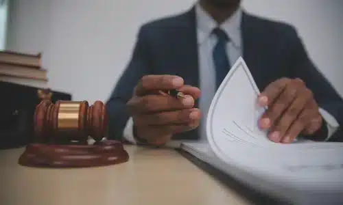 محامي قضايا إساءة معاملة نزلاء دور رعاية المسنين يجلس خلف مكتب ويقرأ صفحات من ملف قضية داخل مكتب محاماة في هيوستن.