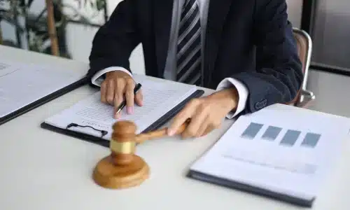 محامي تعويضات العمال يشير إلى ملفات قضية على الطاولة أثناء القراءة داخل مكتب محاماة في هيوستن.