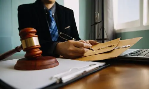محامي قضايا عضة الكلب يحمل مظاريف تحتوي على مستندات يحتاجها العميل لقضيته.