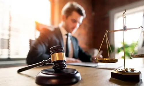 محامي قضايا الأخطاء الطبية يراجع مستندات داخل مكتب مضاء جيداً.