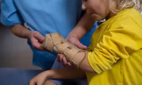 مختص يساعد طفل حضانة بعد تعرّضه لإصابة.