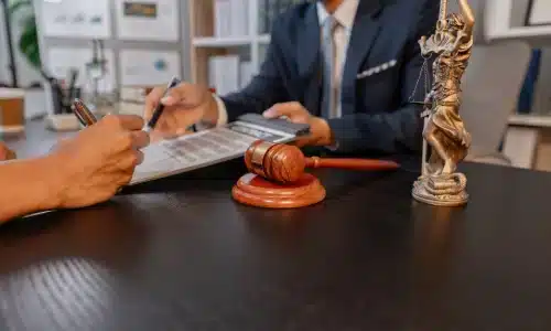 محامي حوادث الركوب عبر التطبيقات في نوجاليس يناقش مسائل قانونية مع عميل ويُراجع المستندات في المكتب.