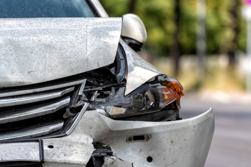 Una luz intermitente dañada y la parte delantera de un vehículo después de chocar lateralmente con otro automóvil.