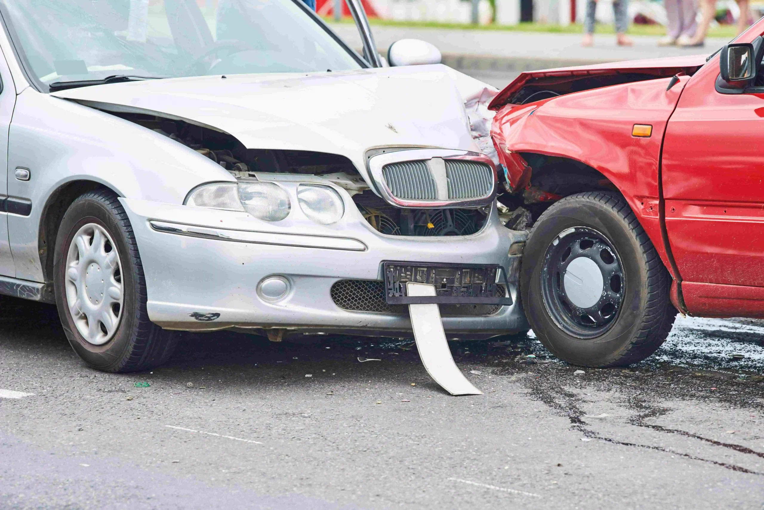 Un automóvil gris y una camioneta roja en un accidente frontal.