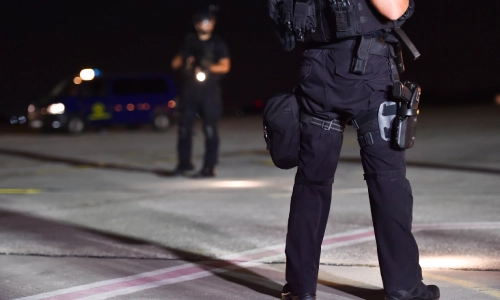 Dos oficiales policiales en la escena de un accidente de noche hablando entre ellos.