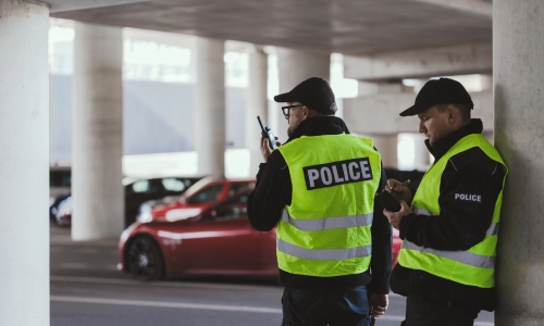 Dos oficiales policiales en un estacionamiento reportando un accidente.