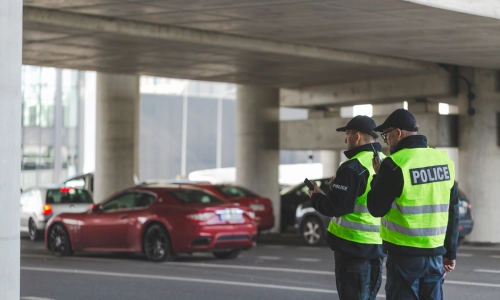 Dos oficiales policiales discutiendo un accidente en un estacionamiento entre ellos.