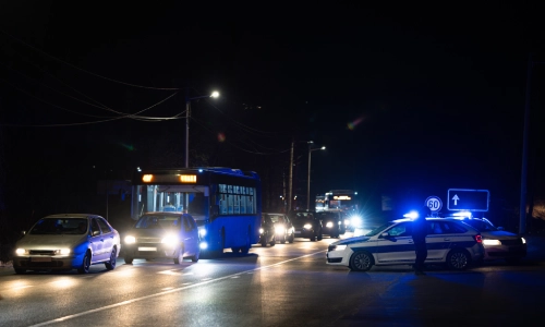Autos policiales al lado de la carretera dirigiendo tráfico lejos de un accidente.