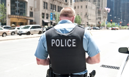 Un oficial de policía de espaldas que parece estar escribiendo en su cuaderno.