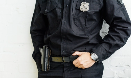 Una toma a la altura del pecho de un oficial de policía de pie con las manos en la cintura.