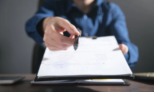 Un oficial de policía entregando formularios para que los completes.