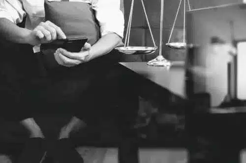 Un abogado de lesiones cerebrales utiliza su celular en una oficina legal.