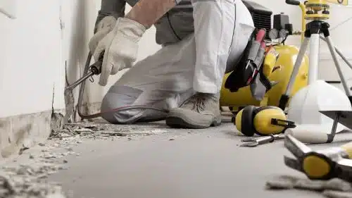 Trabajador de construcción reparando una pared dañada en una obra
