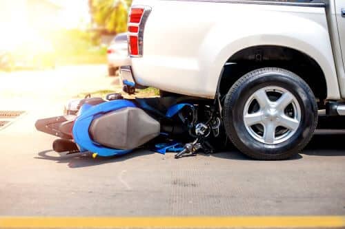 A photo of an accident in which a motorcycle has collided with a car