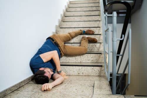 A man slips and falls down the stairs, which can be a common cause of slip and fall accidents