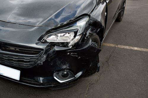 An image of a parked car with damage to the front end after a car accident