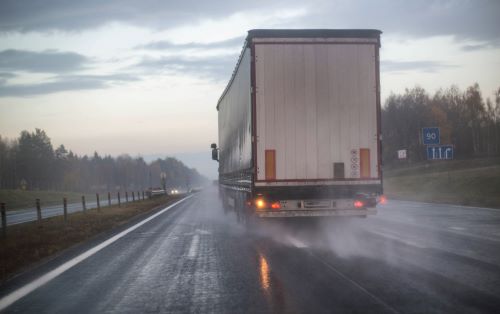 A large truck drives dangerously on Georgia roads in the rain.