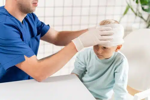 A child with a head injury is cared for by a doctor.