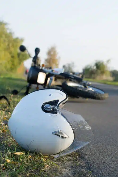 A motorcycle and motorcycle helmet are pictured in the road after an accident.