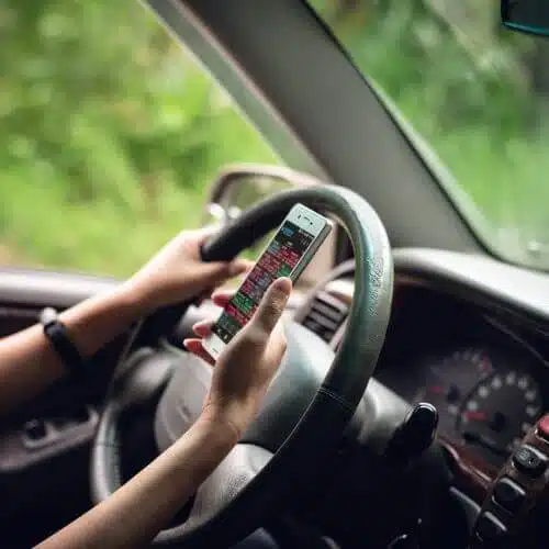 A distracted woman uses a cell phone while driving.