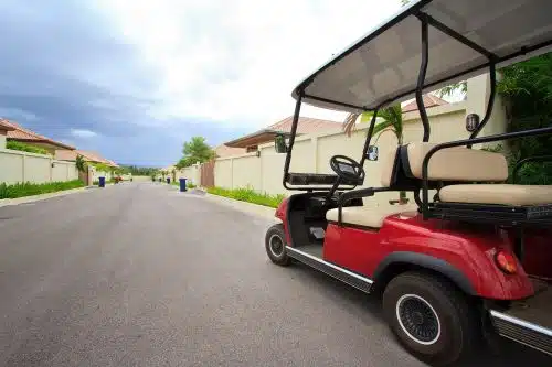 A golf cart is parked on a residential street.