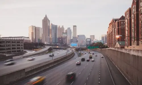 The Atlanta skyline in the evening, with traffic rushing along the highway.