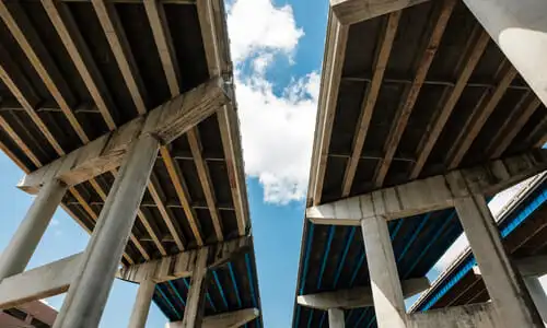An underside view of Interstate 95 and with visible signs of wear on its columns.